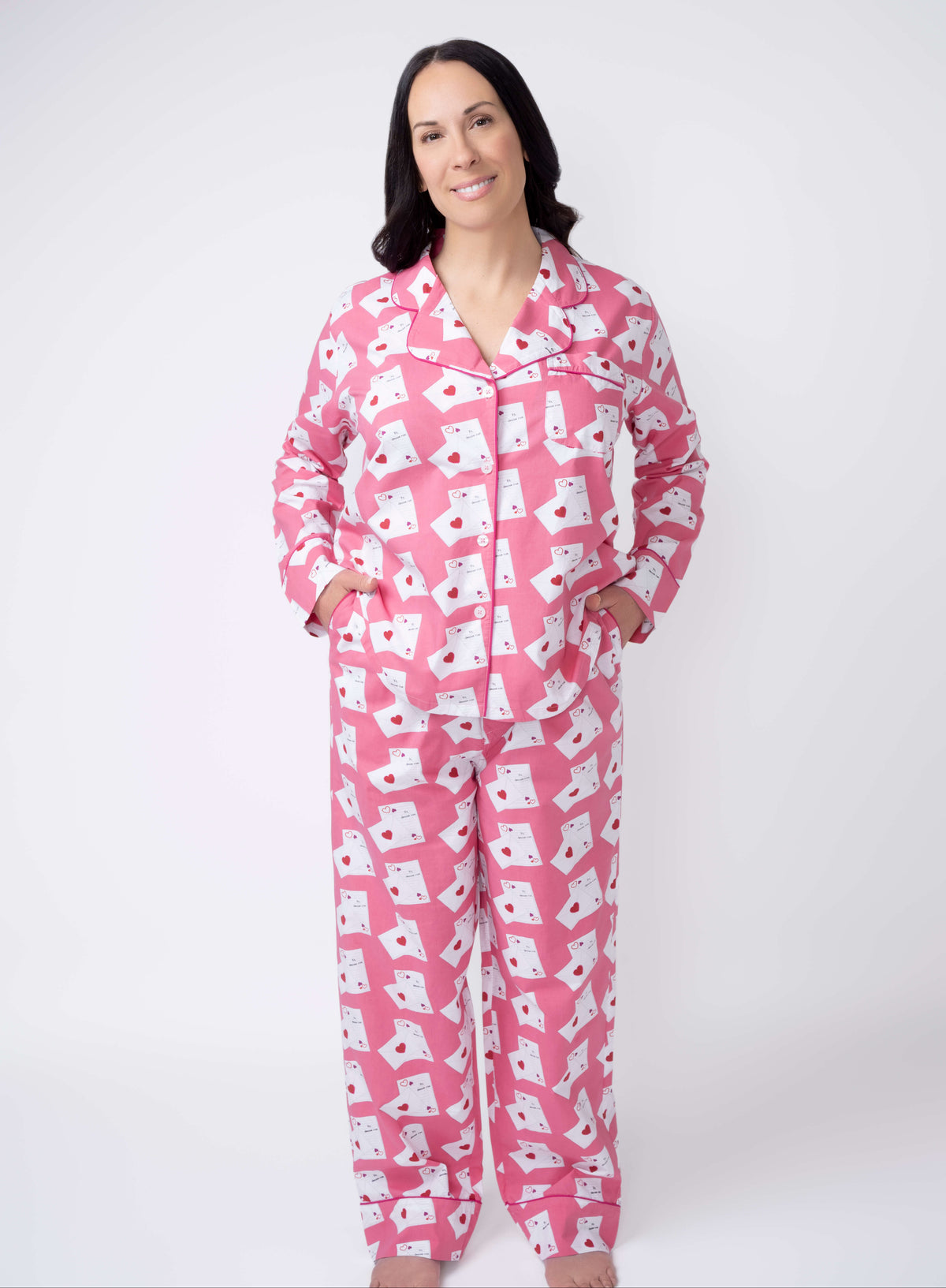 Woman wearing pink pajamas with white patterns on a white background