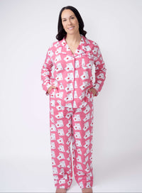 Woman wearing pink pajamas with white patterns on a white background