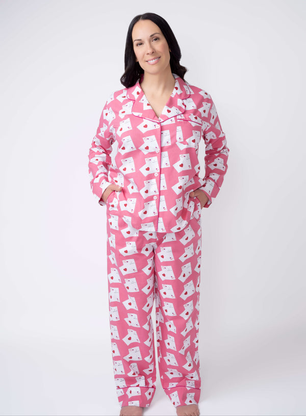 Woman wearing pink pajamas with white patterns on a white background