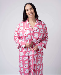 Woman wearing a pink robe with white patterns on a plain background