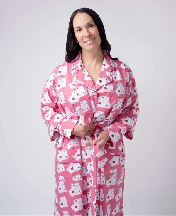 Woman wearing a pink robe with white patterns on a plain background