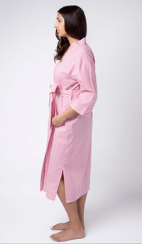 Woman wearing a pink robe against a white background