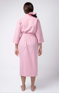 Person wearing a pink robe on a white background