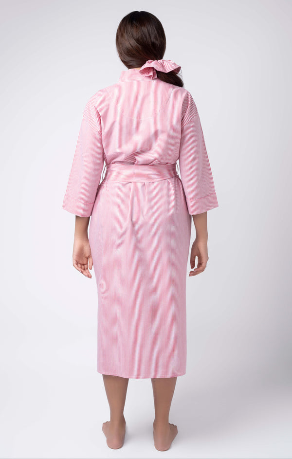 Person wearing a pink robe on a white background