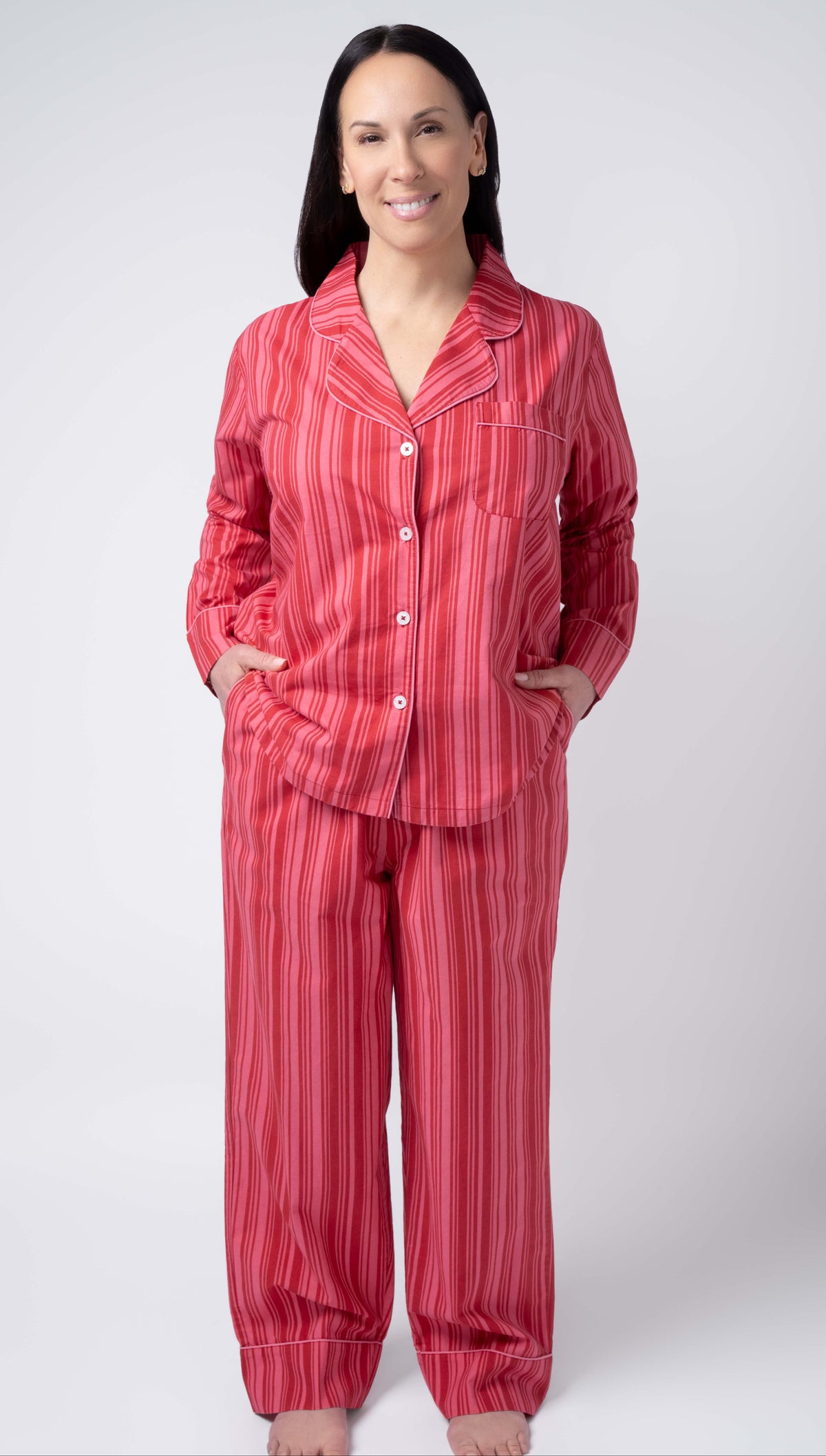 Woman wearing a red striped pajama set on a white background