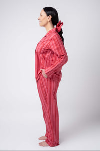Woman wearing a red striped pajama set on a white background