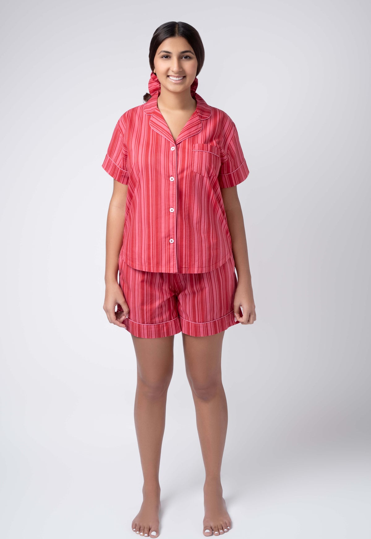 Woman wearing a red striped pajama set on a white background