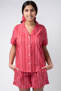 Woman wearing a red striped pajama set on a white background